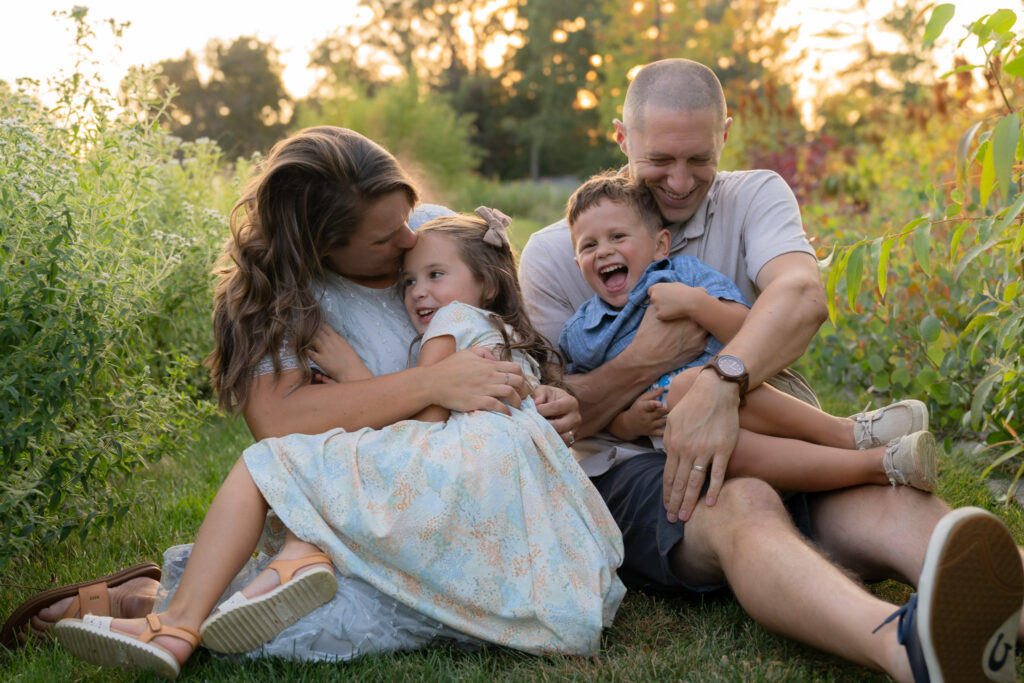 Family cuddling and laughing together with MelMarie Photography during a family photography session in West Bend Wisconsin