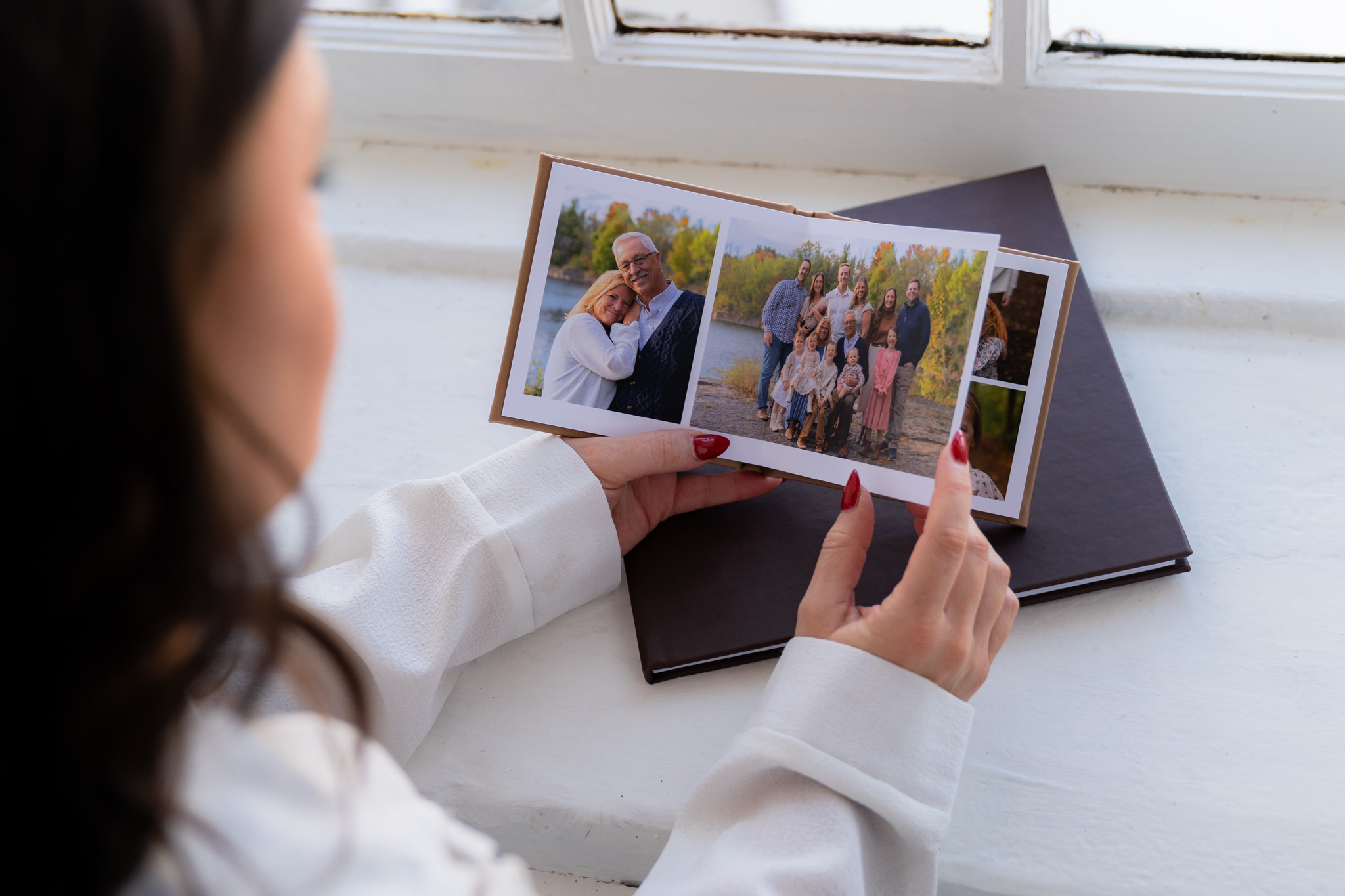 Young girl holding a professionally printed family photography album in West Bend Wisconsin