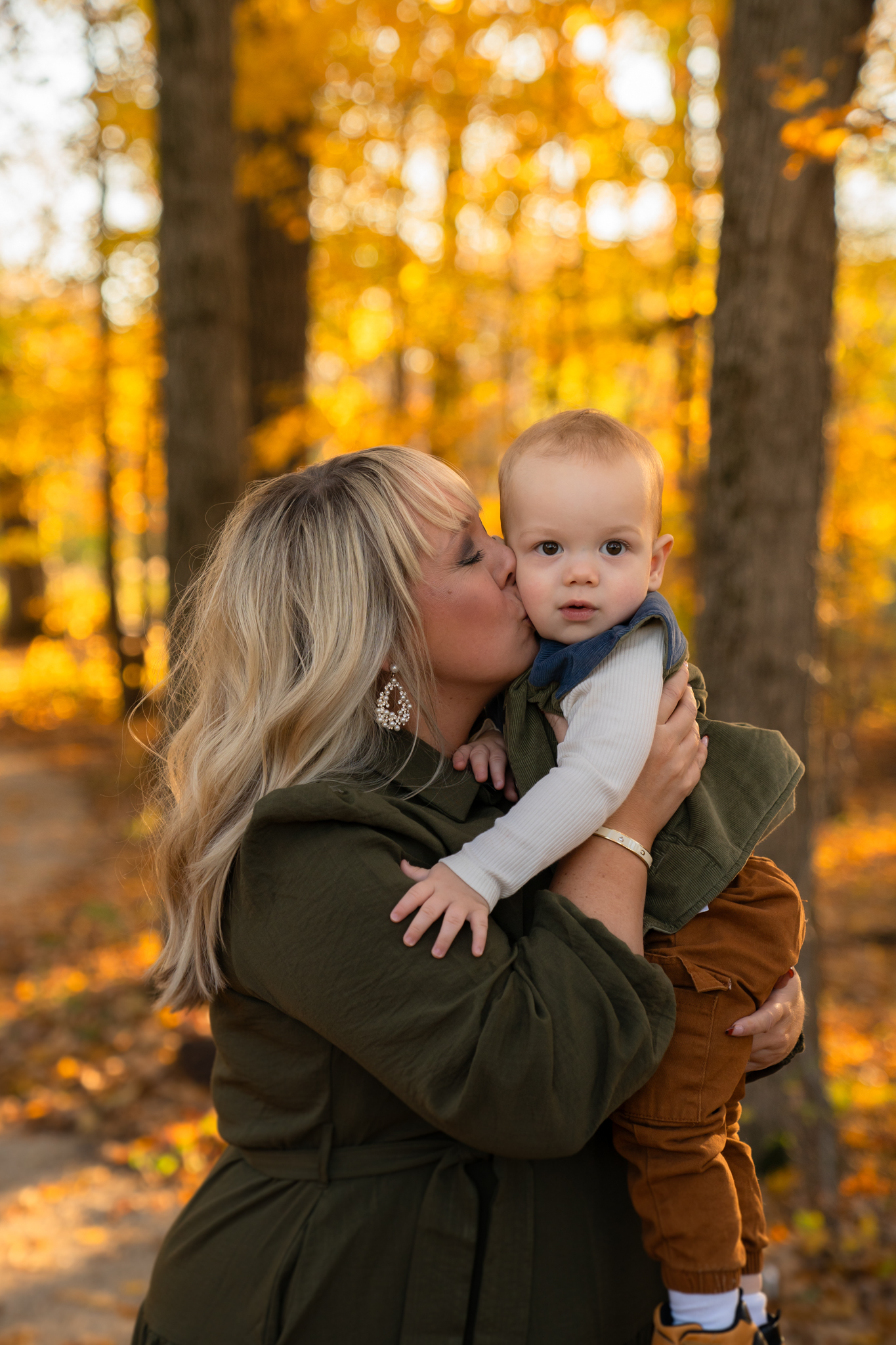 Mom kissing her son on his cheek 