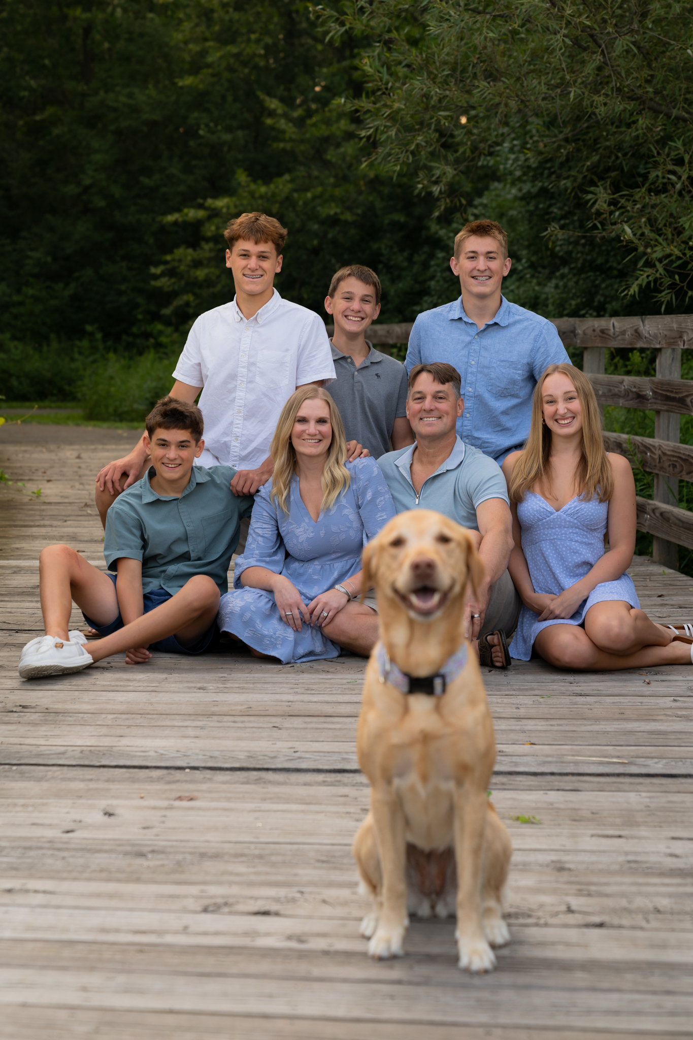 Family with their dog posing on bridge