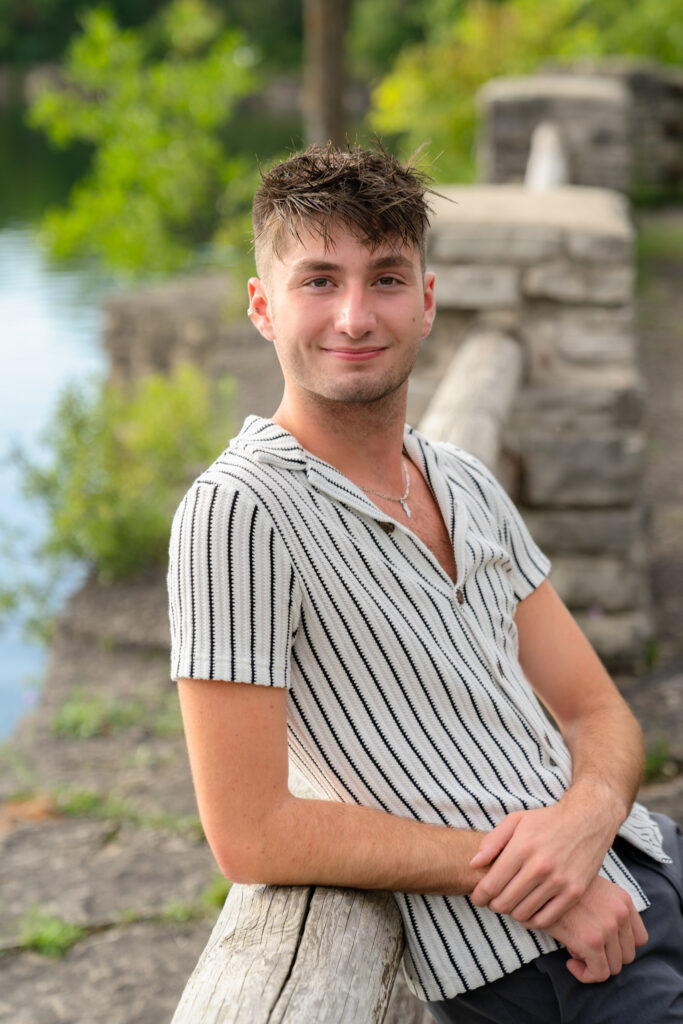 Striped shirt with back against railing