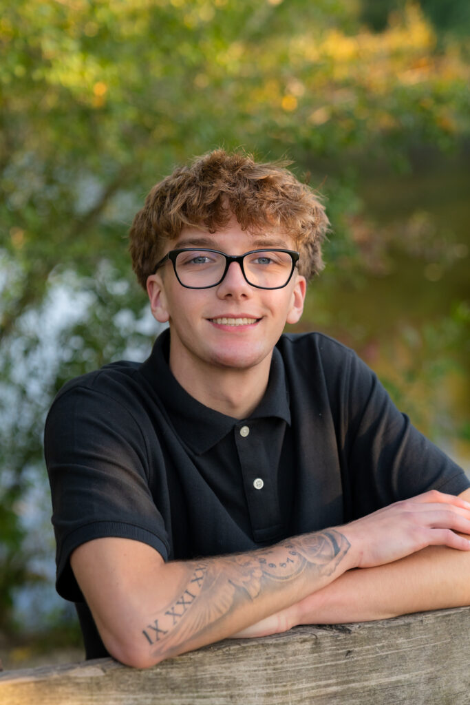 Young man with glasses leaning on a bridge