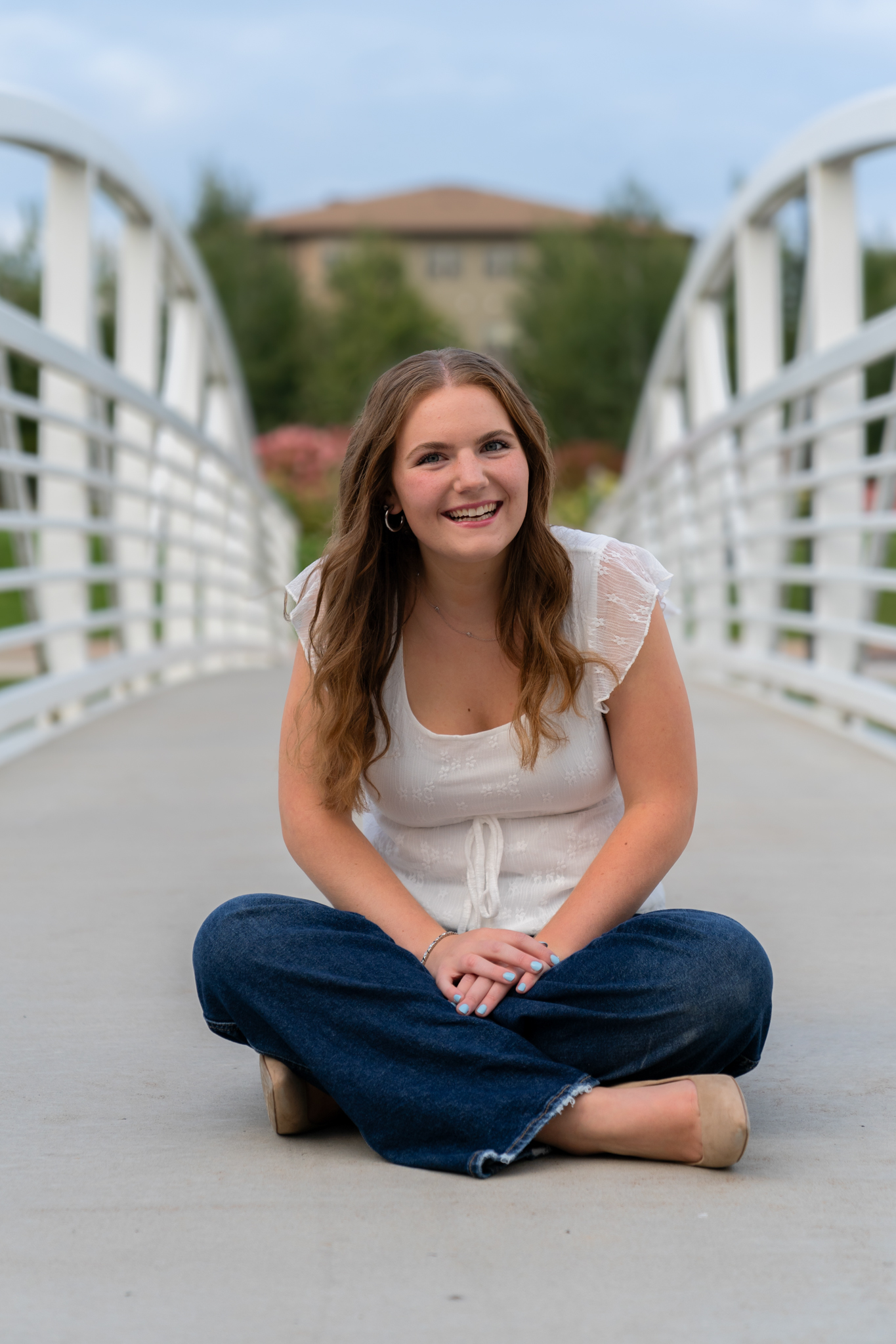Sitting on bridge cross legged and grinning for camera