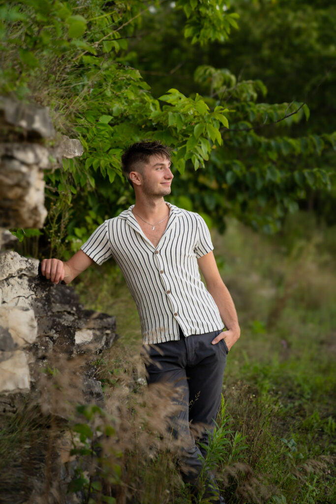 Senior boy leaning up against lannon stone wall in Menomonee Falls Wisconsin