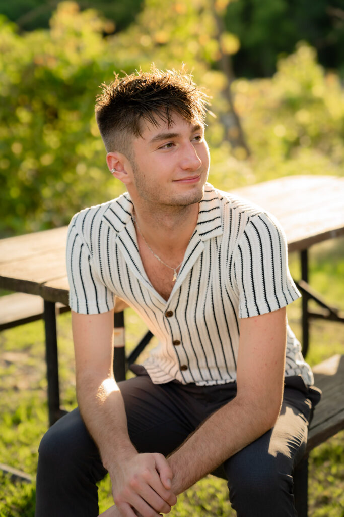 Man sitting on table leaning forward and smiling