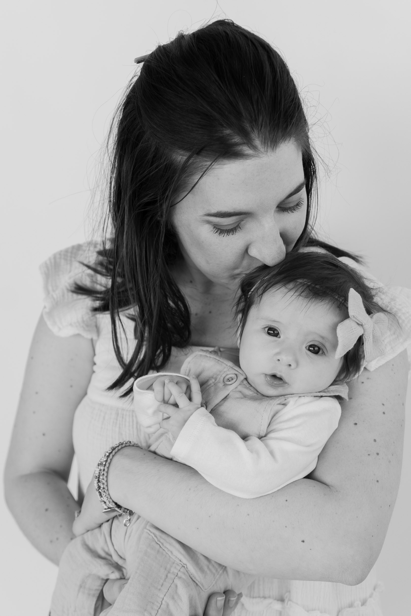Mother kissing her newborn baby on the head