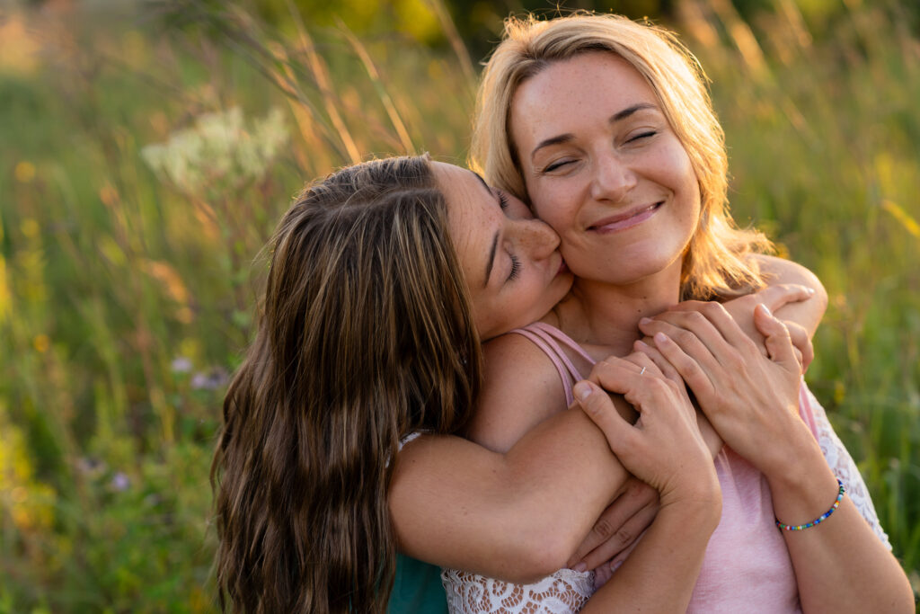 Daughter kissing her mom on the cheek during a mother-daughter photo session in West Bend, Wisconsin