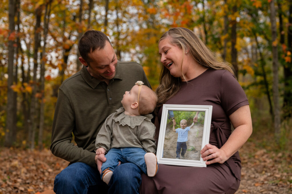 Mom and Dad smiling down at their daughter during fall mini session in Menomonee Falls