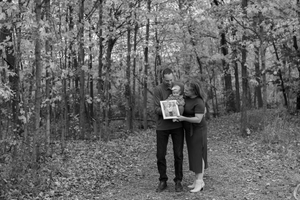 Family of four standing in woods during family photography session during fall