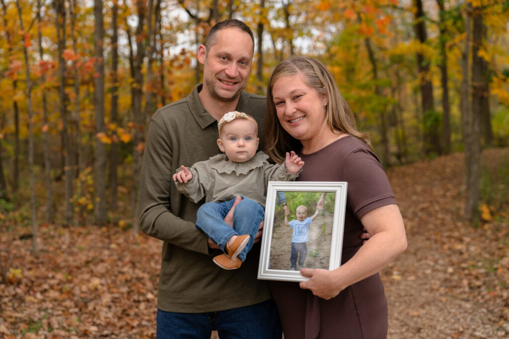 Family smiling at camera during a family photo session during fall season