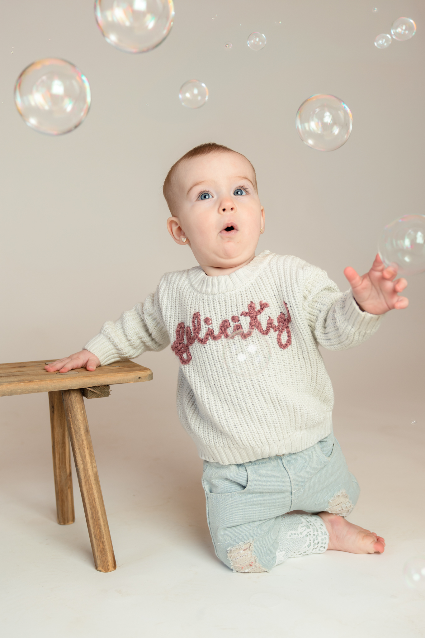 Little girl making cute face at bubbles during her one year milestone session in Cedarburg Wisconsin