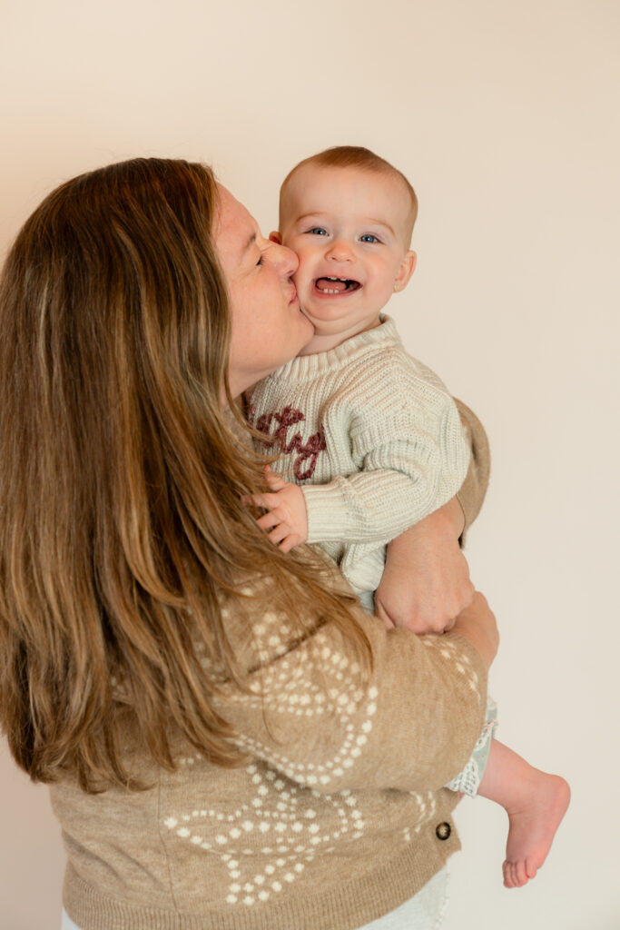 Mother kissing her daughter on the cheek during studio milestone session in Cedarburg