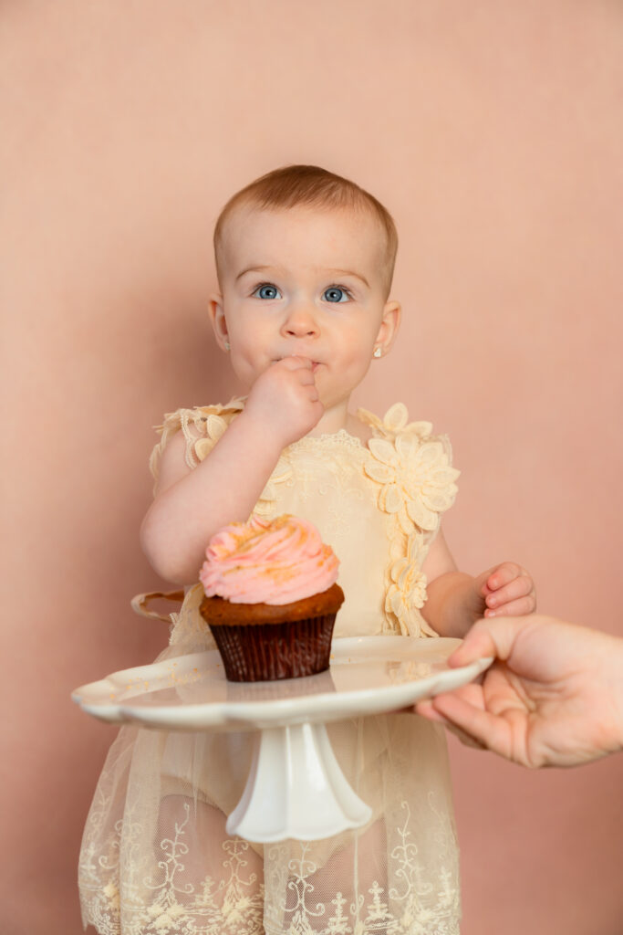 Felicity putting the cupcake in her mouth and tasting it during cake smash in Cedarburg Wisconsin