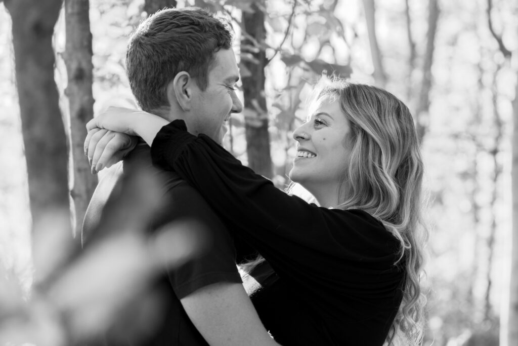 A couple candidly smiling with one another during photography session 