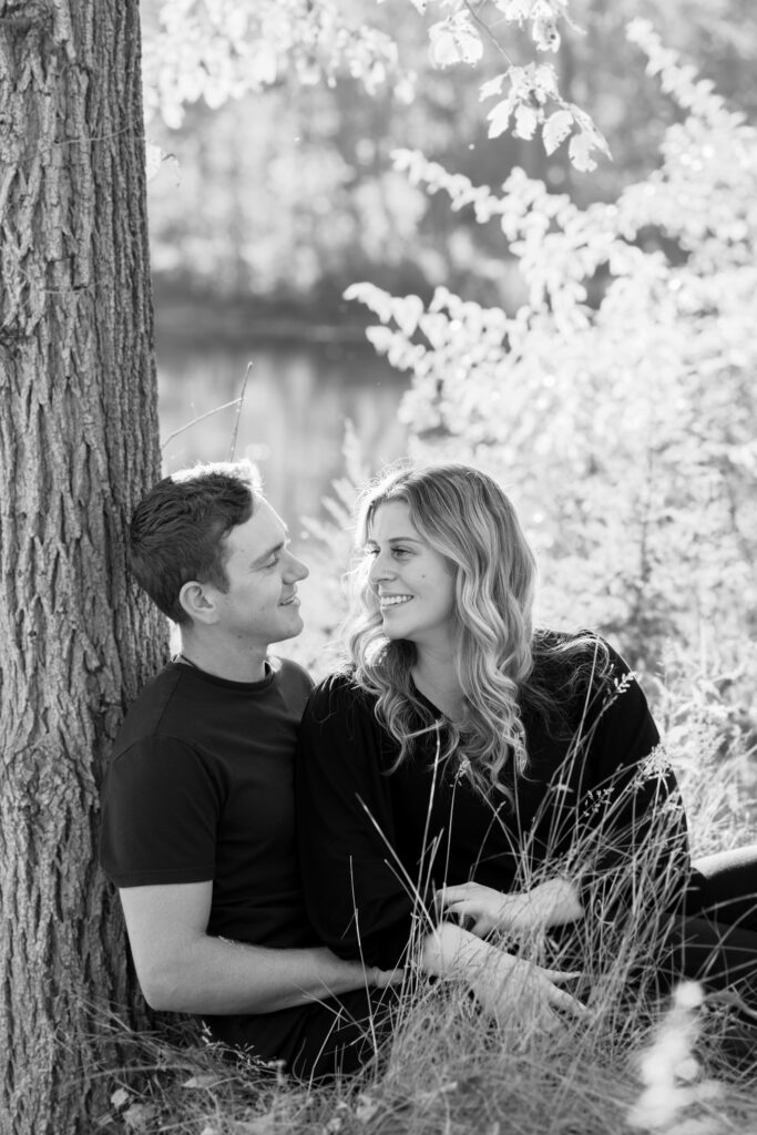 Girlfriend and boyfriend sitting under a tree during golden hour lighting