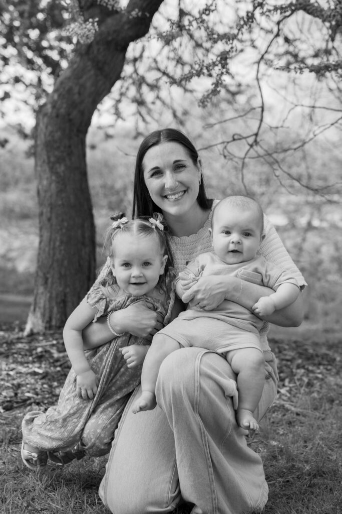 Mother holding her two children in Frame Park formal gardens in Waukesha, Wisconsin