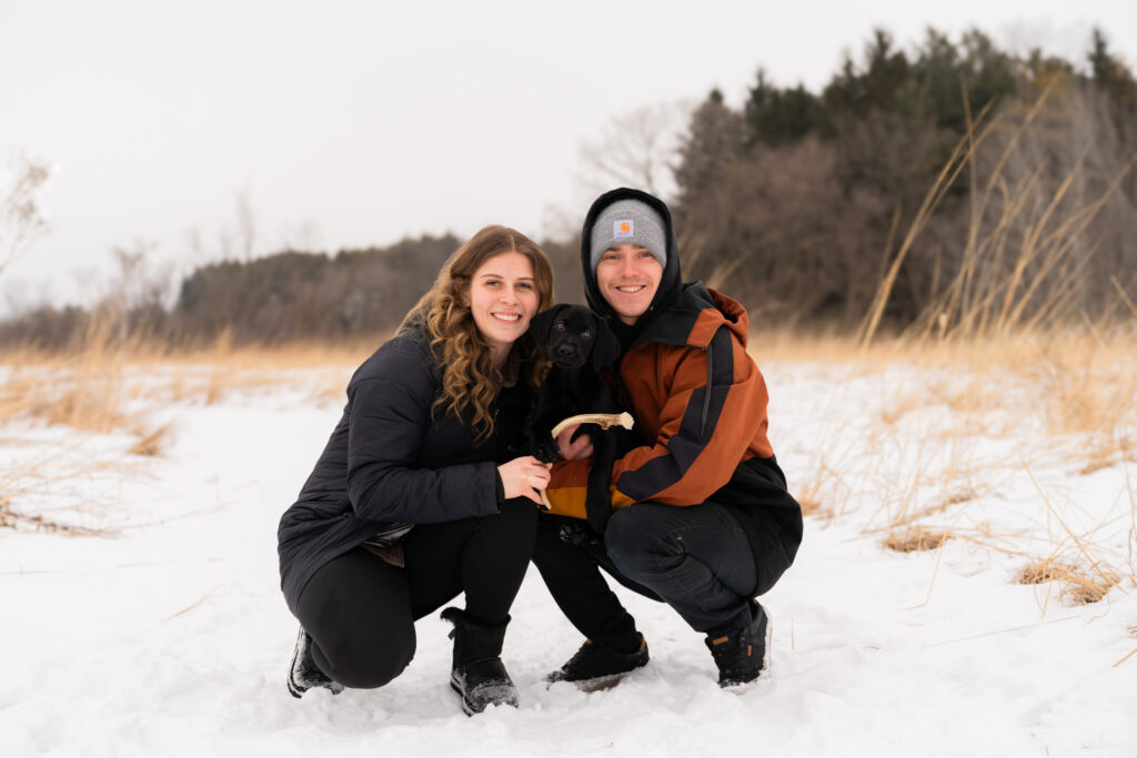 couple holding small dog winter photography session Wisconsin