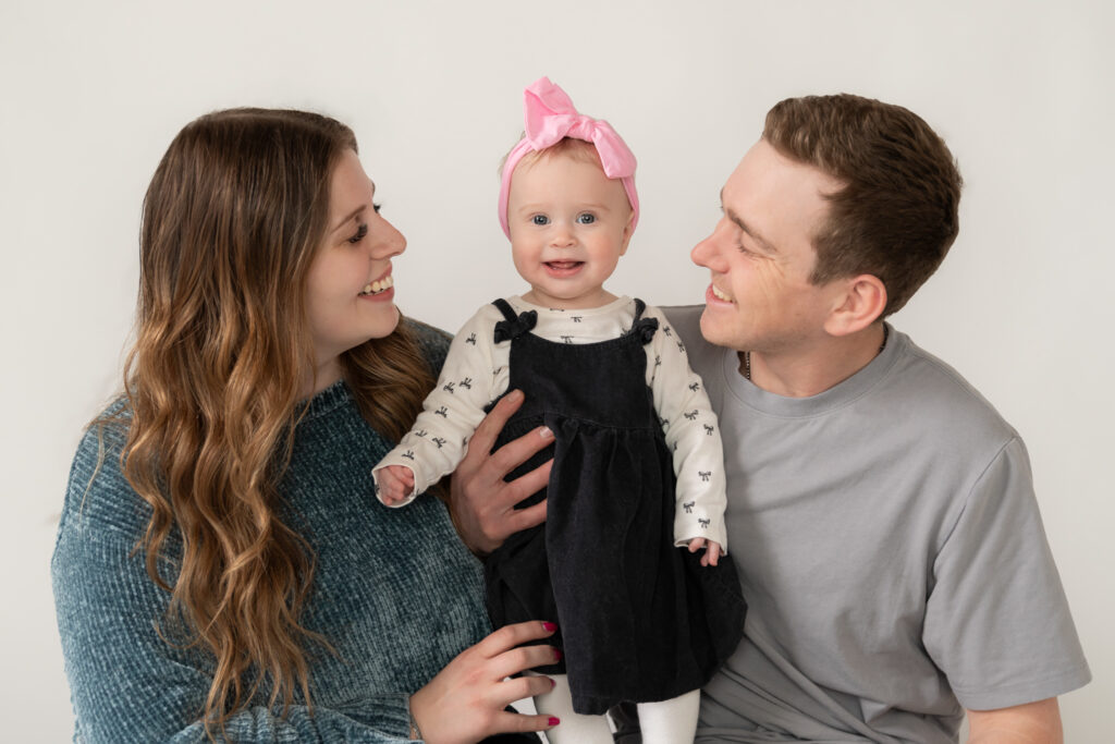 Family of three posing for family portrait in studio in cedarburg wisconsin