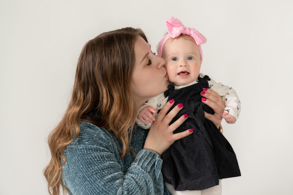 mother kissing her daughter on the cheek during milestone photography session in cedarburg wisconsin