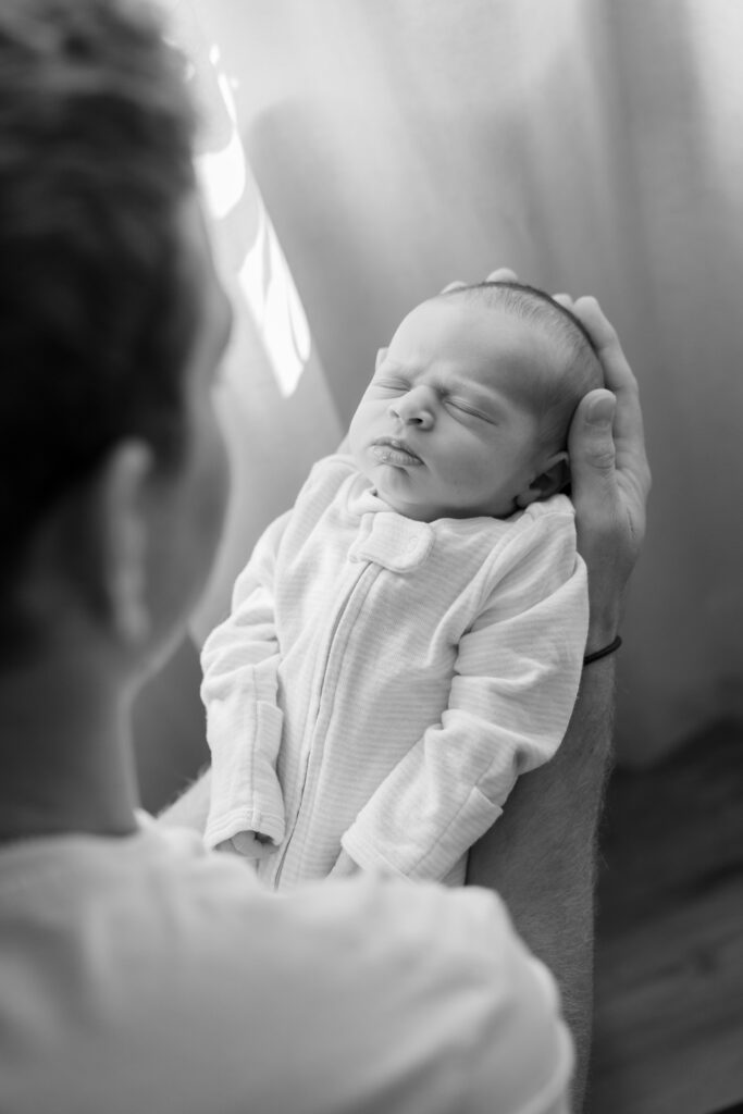 Photo of newborn baby in dads arms