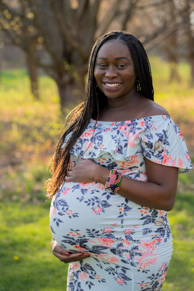 Pregnant mother holding her belly and smiling during her maternity photography session in milwaukee wisconsin