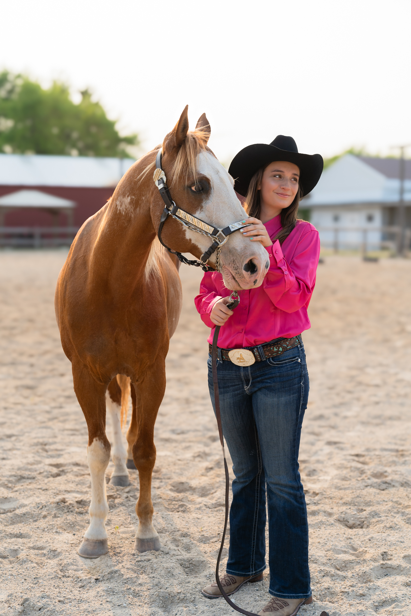 Senior photography portrait of girl and her horse smiling off into the distance