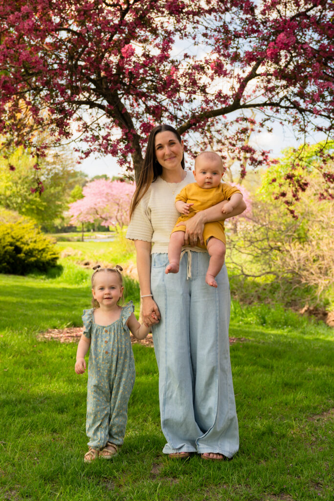 A mother and her two children smiling at the camera during a mommy and me spring session in Frame Park