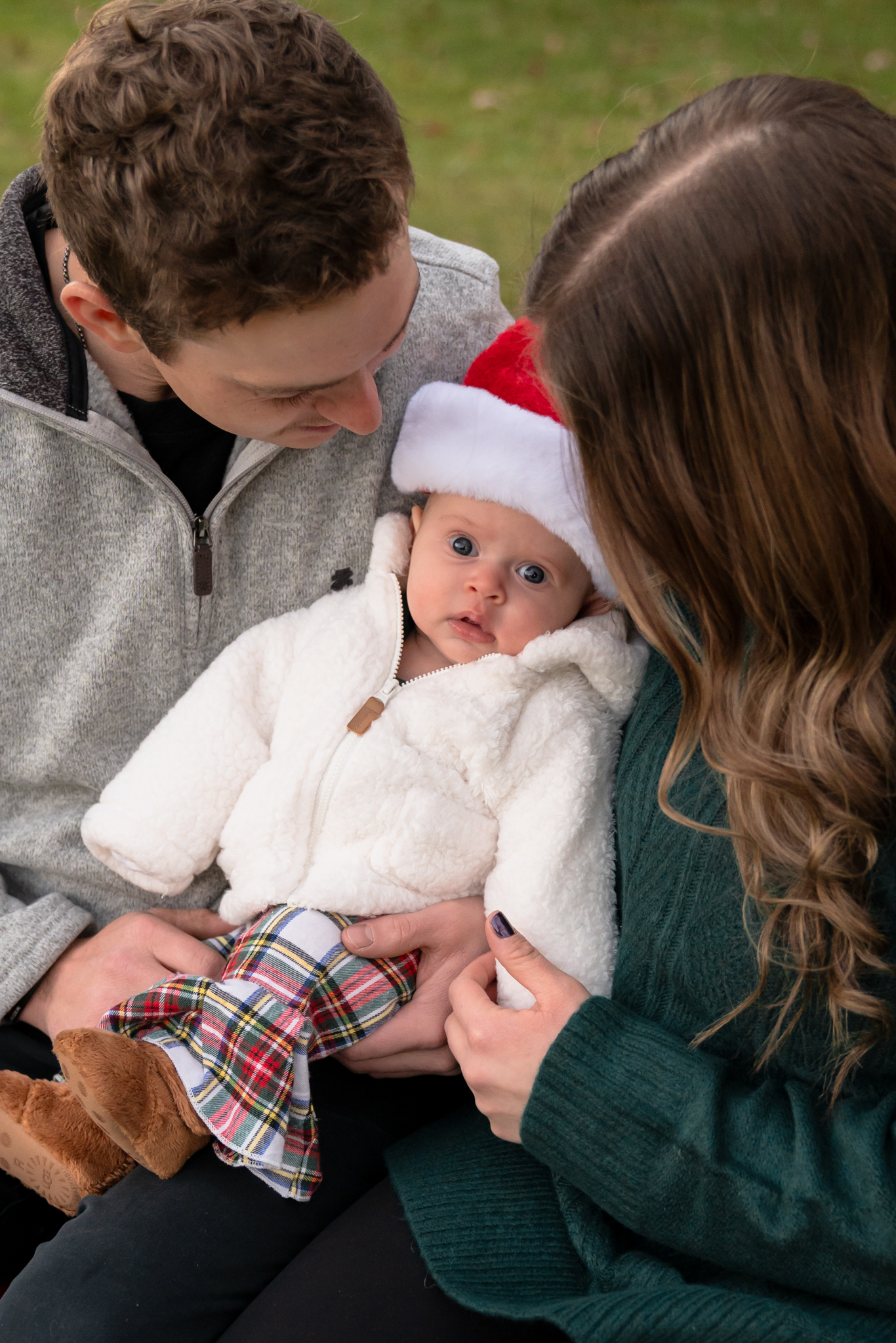 Mom and dad holding their daughter in their lap during christmas mini session in west bend wisconsin