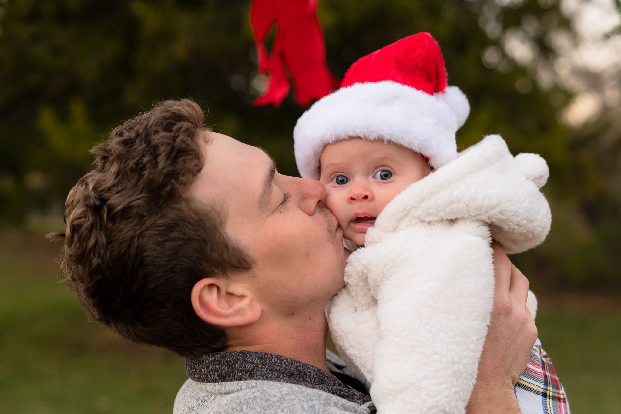 Father kissing his daughter on the cheek during family mini session in west bend wisconsin