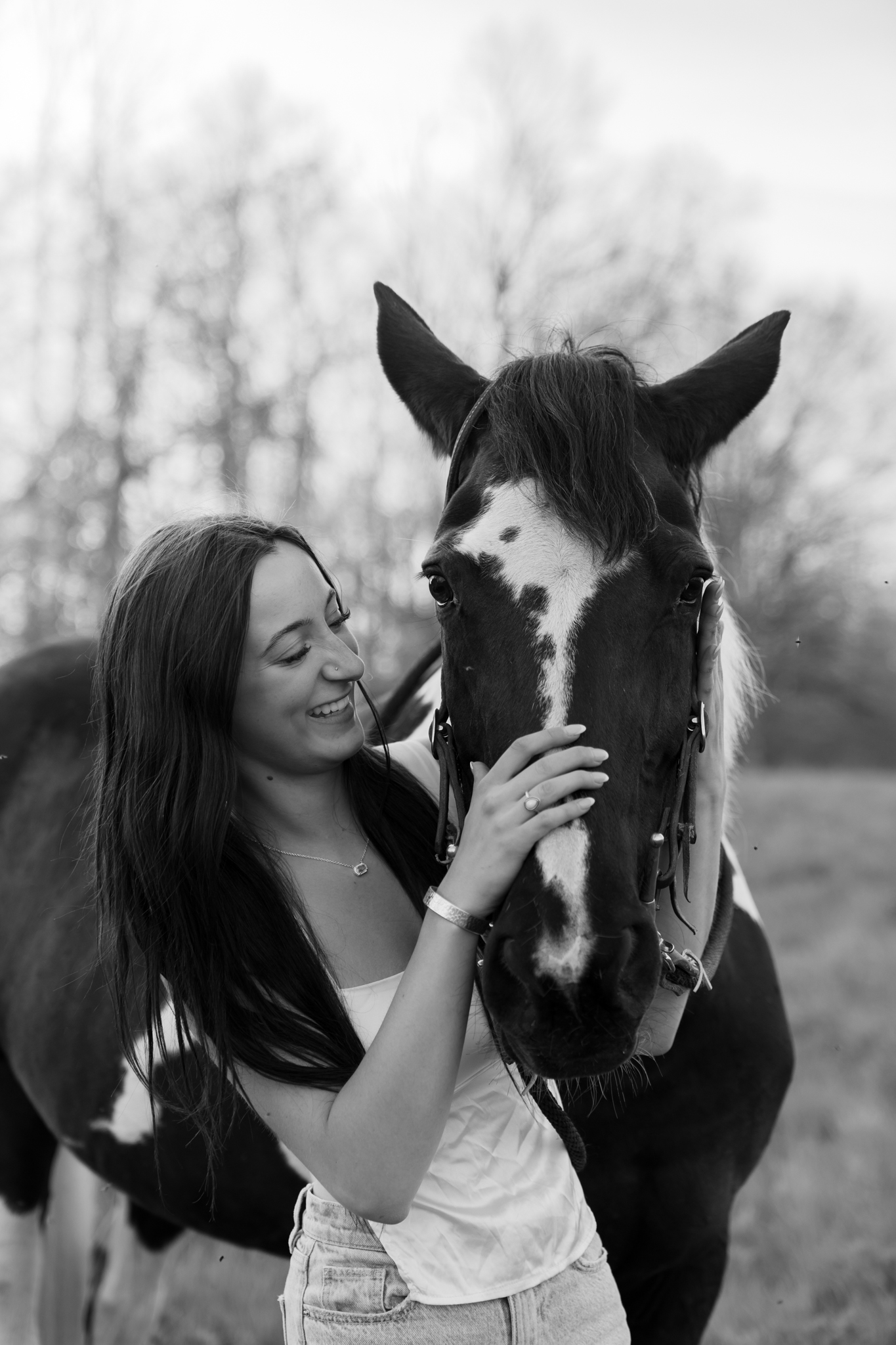 Young girl hugging her horses nose and laughing during photography session in Port Washington Wisconsin