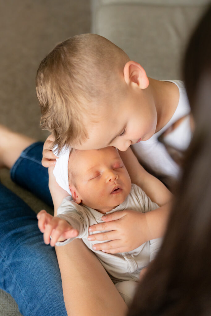 Little brother hugging his sister during newborn photography session in home in oostburg wisconsin