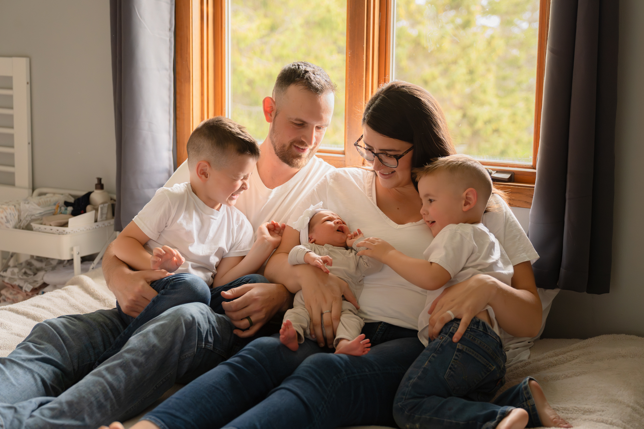 Family candidly interacting with eachother during newborn photography session in Oostburg, wisconsin